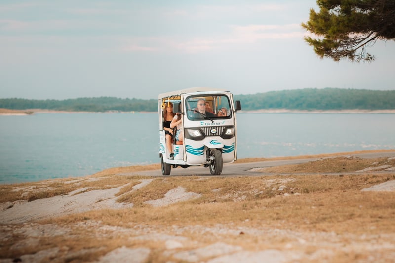 Tuk-tuk cruising along Medulin coastline with sparkling blue Adriatic Sea